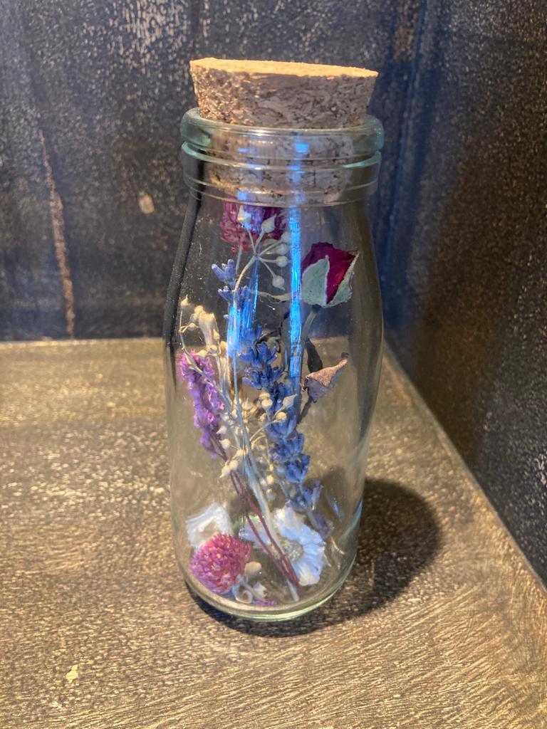 Klein melkflesje met droogbloemen