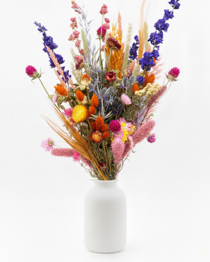 Luxe droogbloemen boeket met statice, craspedia en warme tinten in studiolicht.